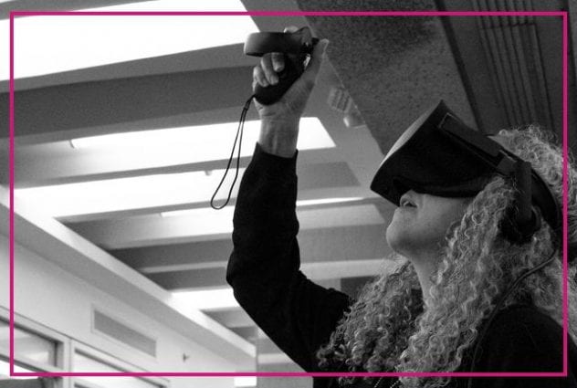 Black and white image of a woman with gray, curly hair using a virtual reality set