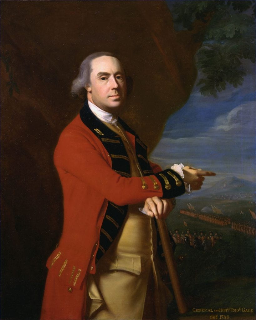 A man dressed in an 18th century British officer uniform standing three quarters to the left of the image, pointing with his left hand across his chest to something behind him. He stands in front of a scarlet curtain which is pulled aside to reveal troops amassed and marching in the distance.